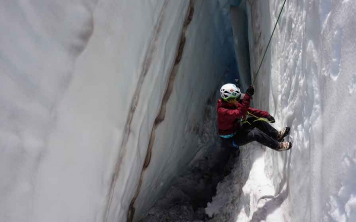 a person rappels into a snowy crevice on a mountaineering expedition in the pacific northwest 